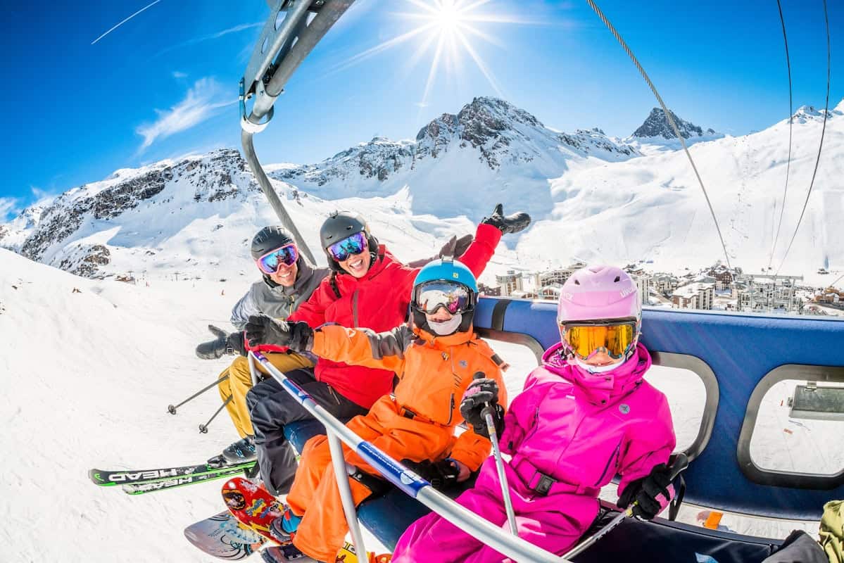 Famille skiant à Tignes Val Claret avec vue sur les montagnes enneigées.